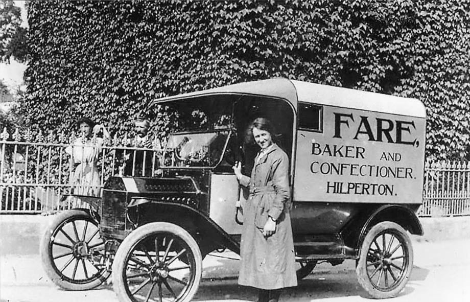 A motor van lettered for Fare, baker and confectioner, with a group of children and a woman standing alongside.